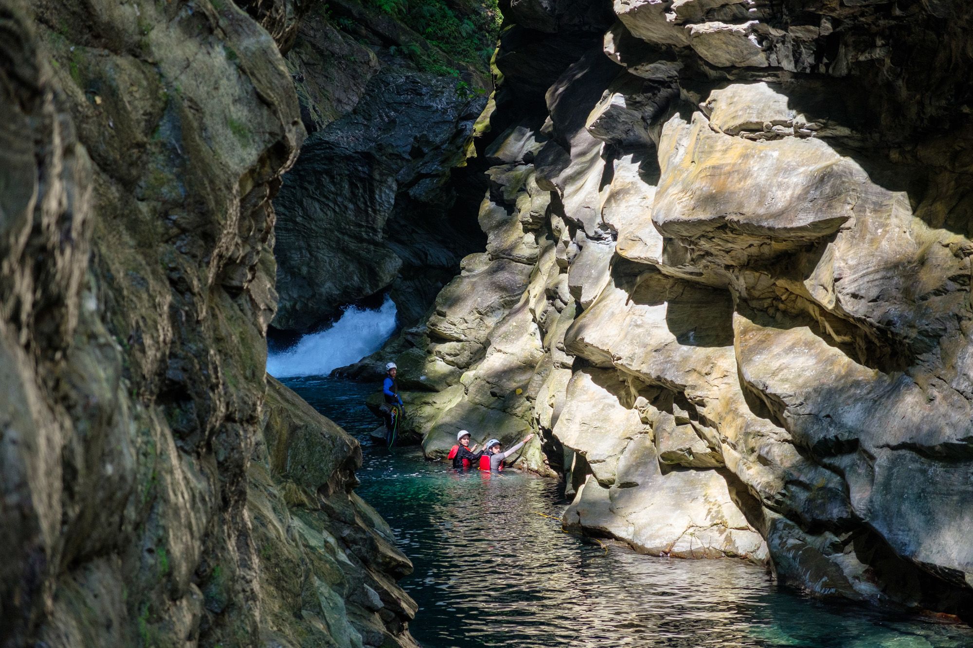 deep gorge leading to a bend in the river with a raging waterfall